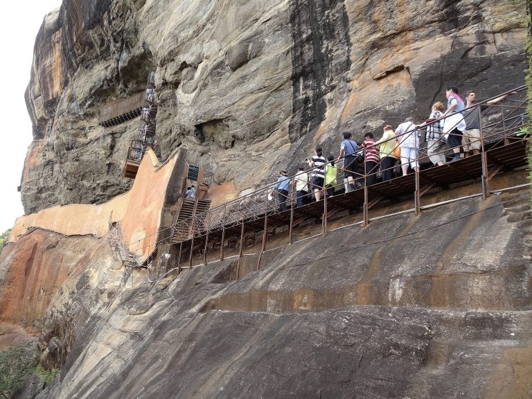 Visitors on the Mirror Wall walkway climbing Sigiriya Rock