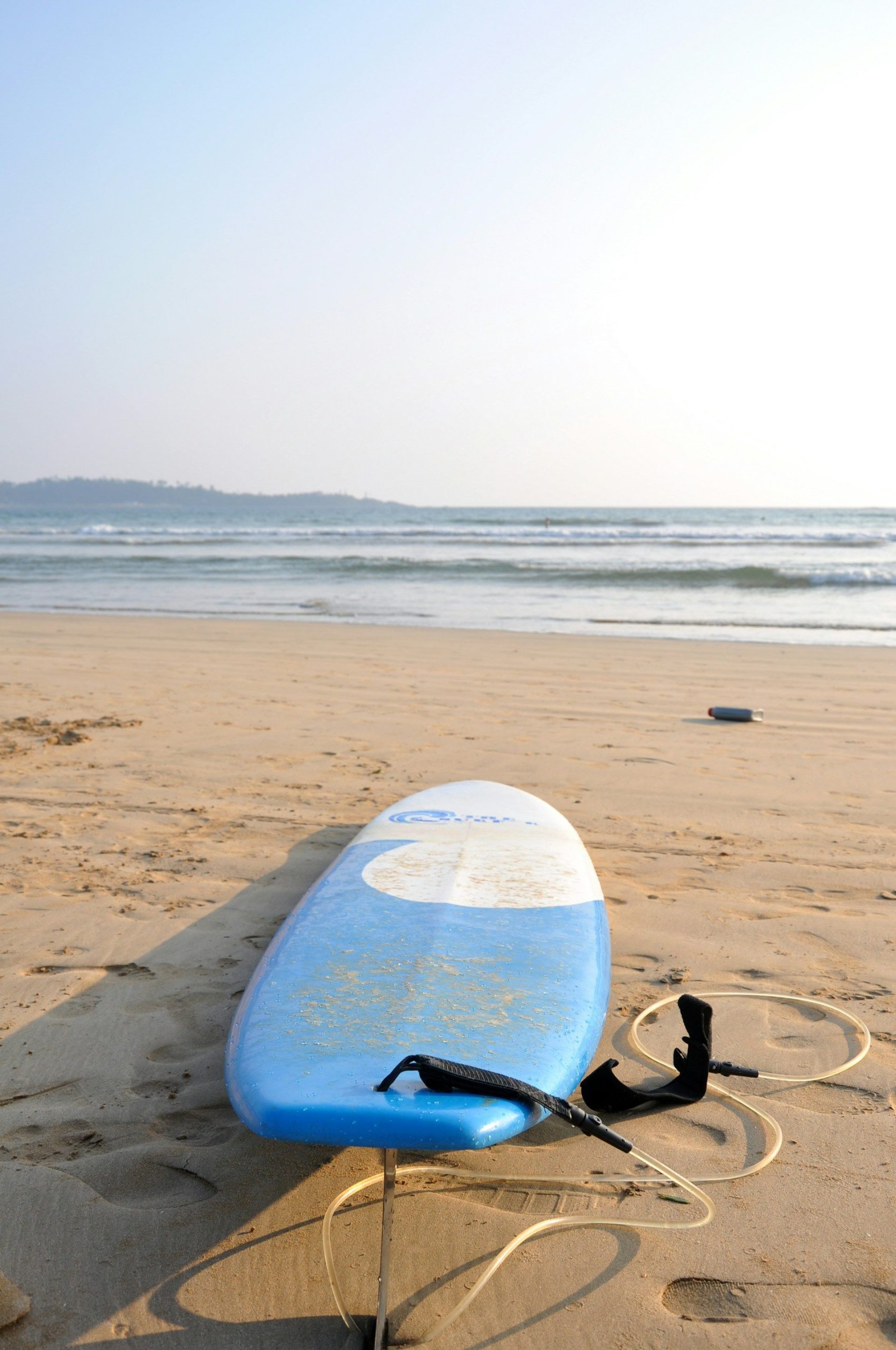 Soft-top surfboard on the sand, ready for a surf lesson